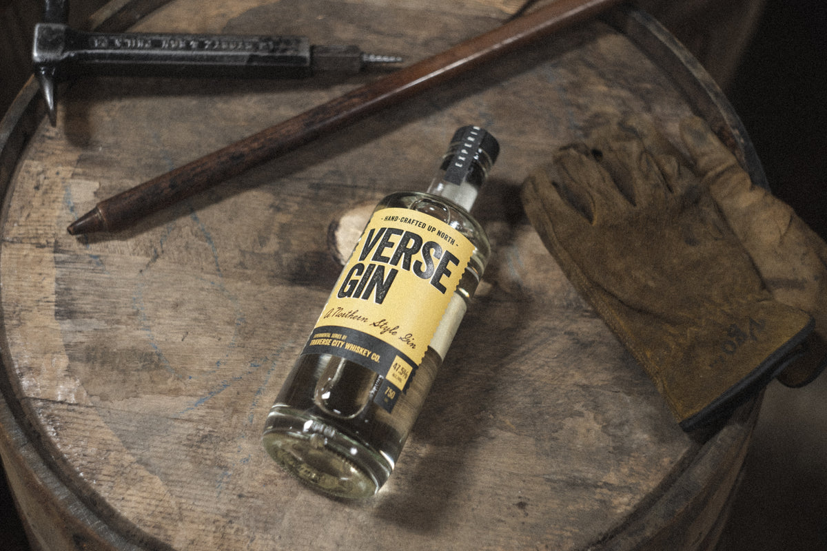 Verse Gin bottle on a barrel head with work gloves