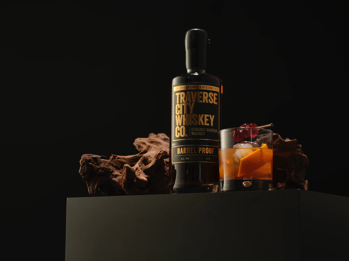 Barrel Proof Bourbon bottle with an Old Fashioned cocktail