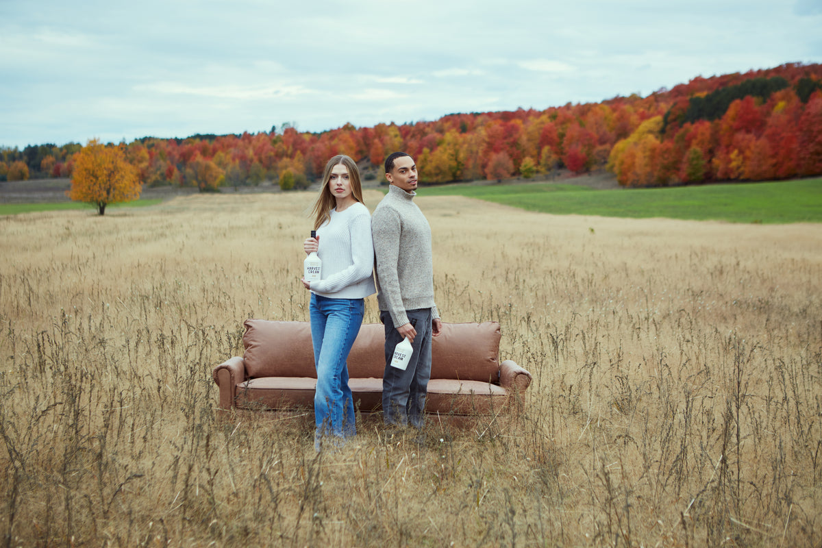 Couple standing by a couch in an autumn field in northern Michigan