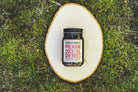 Premium Cocktail Cherries jar on a wood slice in the grass