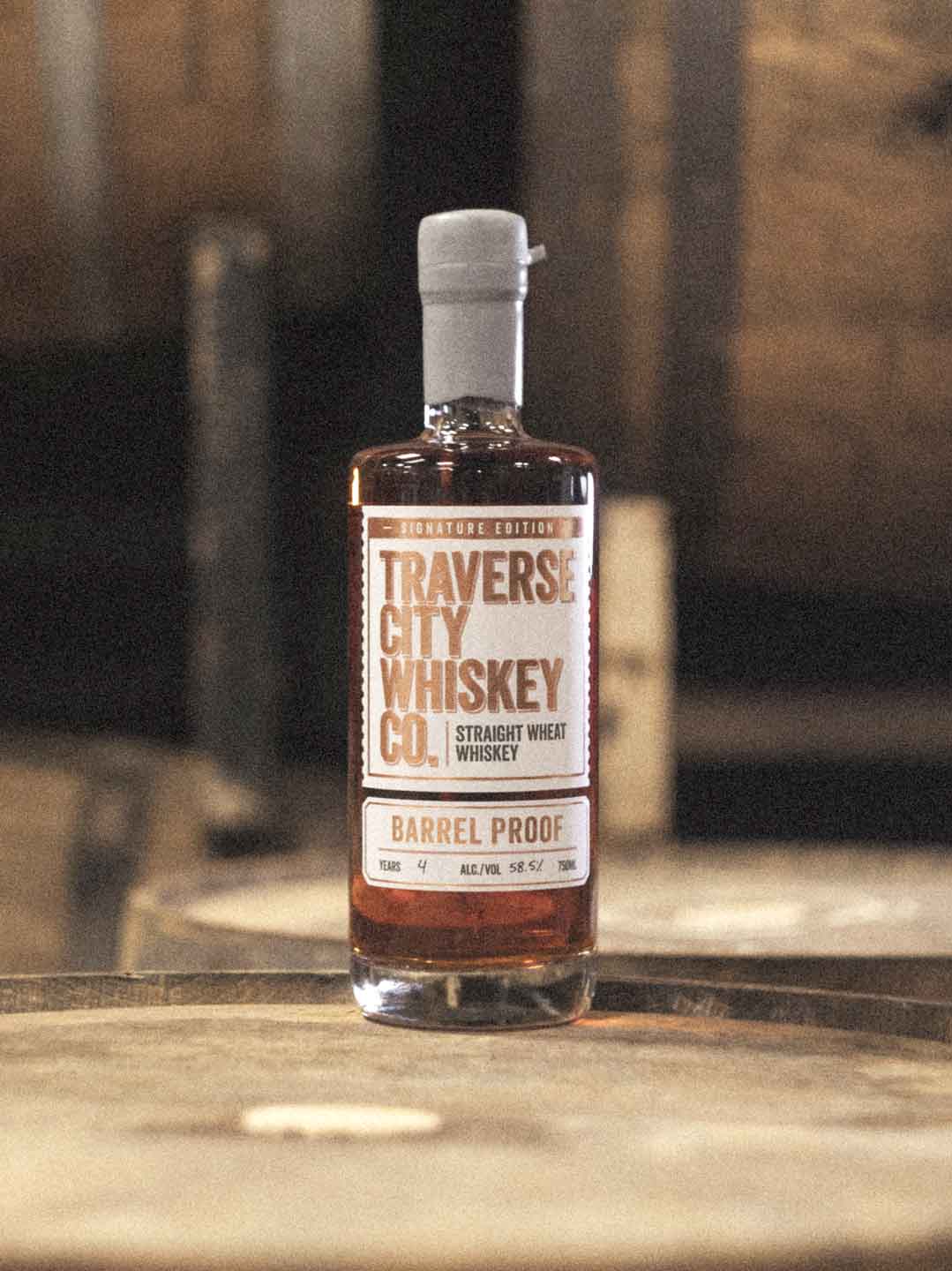 Barrel Proof Wheat bottle on a whiskey barrel