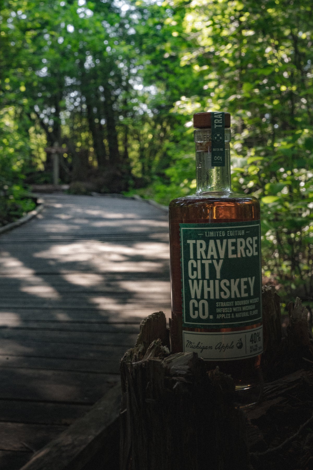 Michigan Apple bourbon bottle on a wooded boardwalk