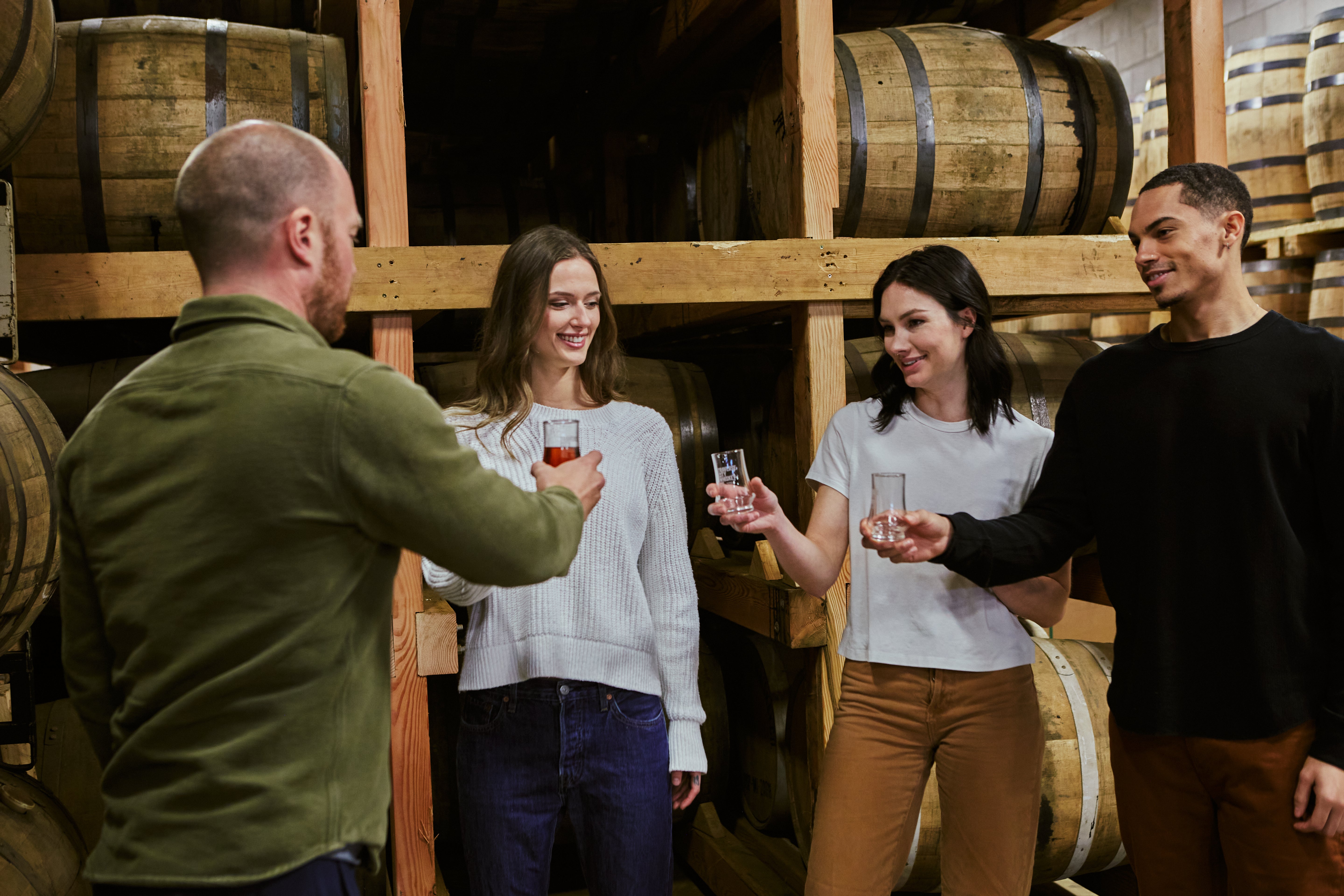 Guests tasting whiskey in the rickhouse on a distillery production tour – Traverse City Whiskey Co.