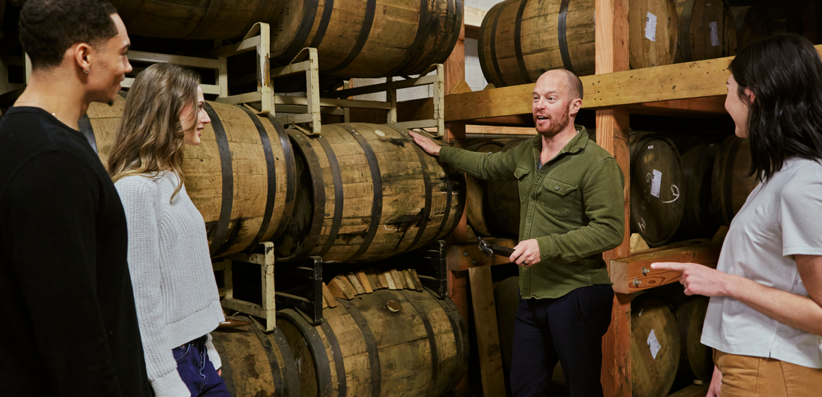 Chris talking with people in between Whiskey Barrels