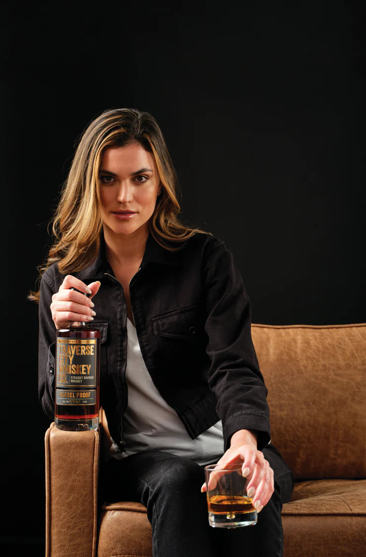 Woman holding Barrel Proof Bourbon and a glass of whiskey