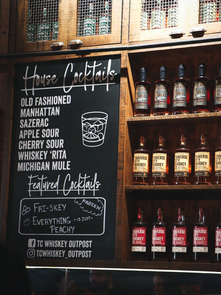The house cocktail chalkboard and bottle wall at the Outpost