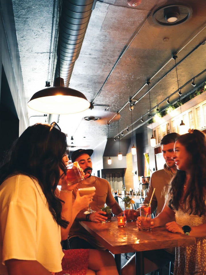 Friends sharing drinks at a table at the Outpost