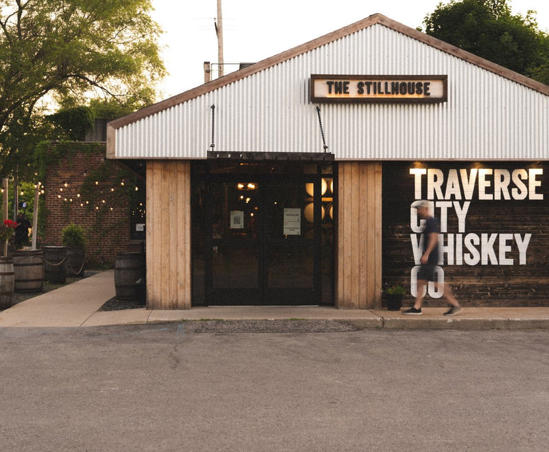 The Stillhouse cocktail bar in downtown Traverse City, with its Traverse City Whiskey mural and barrel-lined patio